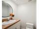 Powder room featuring a round mirror, a countertop with sink, and a white toilet at 6860 Whitman Ct # 32B, Sarasota, FL 34243