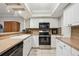 Modern kitchen featuring white cabinets, a dark refrigerator, and a tile backsplash at 6860 Whitman Ct # 32B, Sarasota, FL 34243