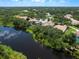 Panoramic aerial view showcasing the property nestled among mature trees with a serene lake in the backdrop at 7003 Lancaster Ct, University Park, FL 34201