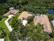 An aerial shot of a home with a private pool in a lush neighborhood near a pond at 7003 Lancaster Ct, University Park, FL 34201