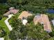 Aerial view of the property showcasing its prime location with mature trees, private pool, and surrounding community at 7003 Lancaster Ct, University Park, FL 34201