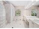 Bright bathroom featuring double sinks, white cabinets, a glass block shower, and a soaking tub at 7003 Lancaster Ct, University Park, FL 34201