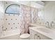 Bathroom featuring shower-tub combo, white cabinetry, and decorative tile accents at 7003 Lancaster Ct, University Park, FL 34201