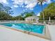 Beautiful community pool area with lounge chairs, umbrellas, and a well-maintained pool house for residents to enjoy at 7003 Lancaster Ct, University Park, FL 34201