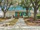 A clubhouse exterior shows an inviting entrance with manicured landscaping, flowers, and trees for a welcoming ambiance at 7003 Lancaster Ct, University Park, FL 34201