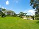 A scenic gazebo sits on a lush green lawn, next to a wood pergola, offering a peaceful outdoor retreat at 7003 Lancaster Ct, University Park, FL 34201