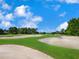 Expansive golf course featuring pristine greens, challenging sand traps, and meticulously manicured fairways under a blue sky at 7003 Lancaster Ct, University Park, FL 34201