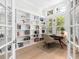 Bright home office featuring built-in shelving, a desk, and views of lush landscaping at 7003 Lancaster Ct, University Park, FL 34201