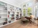 Bright home office featuring built-in shelving, a desk, and views of lush landscaping at 7003 Lancaster Ct, University Park, FL 34201