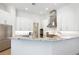 Bright kitchen showcasing white cabinets, stainless steel appliances, and an island with granite countertops at 7003 Lancaster Ct, University Park, FL 34201
