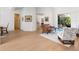 View of living room with light wood floors and ample seating, open to outdoor covered area at 7003 Lancaster Ct, University Park, FL 34201