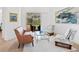 Bright living area featuring a brown leather sofa, stylish chairs, and a clear view to the outdoor pool at 7003 Lancaster Ct, University Park, FL 34201