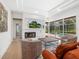 Comfortable living area with fireplace, TV, and scenic view of the pool and landscaping through large windows at 7003 Lancaster Ct, University Park, FL 34201