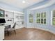 Bright home office with built-in shelves, a desk, and windows with white shutters at 7003 Lancaster Ct, University Park, FL 34201