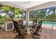 Covered patio with an outdoor kitchen and dining set with beautiful backyard at 7003 Lancaster Ct, University Park, FL 34201