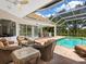 An enclosed pool area offers outdoor seating, grill and beautiful backyard views at 7003 Lancaster Ct, University Park, FL 34201