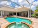 Private pool and spa surrounded by a brick patio and screened enclosure, perfect for enjoying the Florida sunshine at 7003 Lancaster Ct, University Park, FL 34201