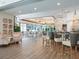 A restaurant interior boasts tables and chairs, bar seating, modern lighting, and expansive windows for beautiful views at 7003 Lancaster Ct, University Park, FL 34201