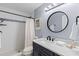 Well-lit bathroom featuring a new vanity, updated shower and round mirror at 714 & 716 Apalachicola Rd, Venice, FL 34285