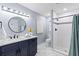 Bathroom with navy cabinets, quartz counters, and a tiled walk-in shower at 714 & 716 Apalachicola Rd, Venice, FL 34285
