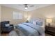 Cozy bedroom features a comfortable bed with blue bedding, a ceiling fan, and plantation shutters at 714 & 716 Apalachicola Rd, Venice, FL 34285