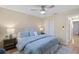 Comfortable bedroom with blue bedding, wood floors, ceiling fan, and ensuite bathroom at 714 & 716 Apalachicola Rd, Venice, FL 34285