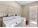 Functional laundry room with a washer, dryer, utility sink, and ample storage space at 714 & 716 Apalachicola Rd, Venice, FL 34285