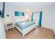 Comfortable bedroom with wood floors, a queen bed, and ocean-blue curtains by the window at 8007 17Th Nw Ave, Bradenton, FL 34209