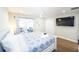 Cozy bedroom with a ceiling fan, a queen bed, an outside patio, and a mounted TV at 8007 17Th Nw Ave, Bradenton, FL 34209