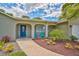 Inviting front entrance featuring a blue front door, outdoor seating, and lovely landscaping at 8007 17Th Nw Ave, Bradenton, FL 34209