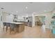 Open-concept kitchen with stainless steel appliances, an island with bar seating, and wood-look tile floors at 8007 17Th Nw Ave, Bradenton, FL 34209