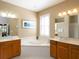 Luxurious bathroom with a large soaking tub, double vanity, and natural light from the window at 8078 Stirling Falls Cir, Sarasota, FL 34243