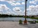 Beach featuring colorful Adirondack chairs with a view of the pond and blue cloudy sky at 8078 Stirling Falls Cir, Sarasota, FL 34243
