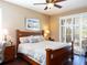 Bedroom features a wooden bed frame, ceiling fan, bedside tables with lamps, and lots of light at 8078 Stirling Falls Cir, Sarasota, FL 34243