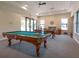 Well-lit billiards room with two pool tables, ceiling fan, and comfortable seating area at 8078 Stirling Falls Cir, Sarasota, FL 34243
