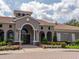 Inviting clubhouse entrance features well-manicured landscaping and classic architectural design at 8078 Stirling Falls Cir, Sarasota, FL 34243