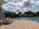 Inviting community pool area with plenty of lounge chairs and shade umbrellas for relaxation at 8078 Stirling Falls Cir, Sarasota, FL 34243