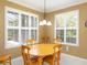 Sunny dining room with a wood table, four chairs, plantation shutters, and a decorative pendant light at 8078 Stirling Falls Cir, Sarasota, FL 34243