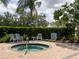 Secluded hot tub area with lounge chairs, surrounded by lush greenery at 8078 Stirling Falls Cir, Sarasota, FL 34243