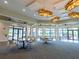 Spacious gathering room with elegant lighting, tables, and chairs at 8078 Stirling Falls Cir, Sarasota, FL 34243