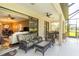 Covered patio featuring comfortable seating, ceiling fan, and a view of the landscaped backyard at 8078 Stirling Falls Cir, Sarasota, FL 34243