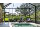 Screened-in pool area with lounge chairs and a scenic view of the lake and surrounding neighborhood at 8078 Stirling Falls Cir, Sarasota, FL 34243