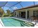 Backyard pool area with a covered patio, comfortable seating, and beautiful tropical landscaping at 8078 Stirling Falls Cir, Sarasota, FL 34243