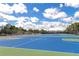 Outdoor basketball courts with blue playing surface and white lines under a bright blue sky with clouds at 8472 60Th N St # 702, Pinellas Park, FL 33781