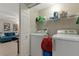Convenient laundry room with washer, dryer, shelving for storage, and easy access from the living area at 8472 60Th N St # 702, Pinellas Park, FL 33781