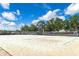 Sandy volleyball court featuring nets and lush greenery under a bright blue sky at 8472 60Th N St # 702, Pinellas Park, FL 33781