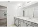 Bright bathroom featuring a double vanity with grey cabinetry, and a large mirror at 8815 Windlass Cv, Parrish, FL 34219
