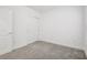An empty, carpeted bedroom with a closet and door at 8815 Windlass Cv, Parrish, FL 34219