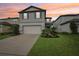 Charming two-story home featuring a manicured lawn, attached garage, and attractive landscaping at 8815 Windlass Cv, Parrish, FL 34219