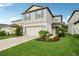 Charming two-story home featuring a manicured lawn, attached garage, and attractive landscaping at 8815 Windlass Cv, Parrish, FL 34219